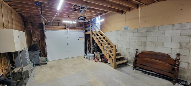 garage with concrete block wall and a garage door opener