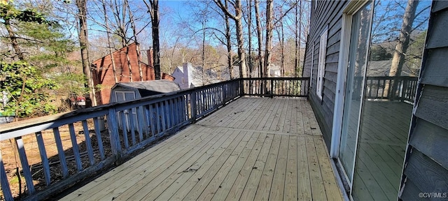 wooden terrace with an outbuilding and a storage unit