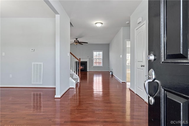 foyer with visible vents, stairway, a ceiling fan, wood finished floors, and baseboards