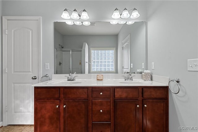 bathroom with double vanity, a stall shower, and a sink