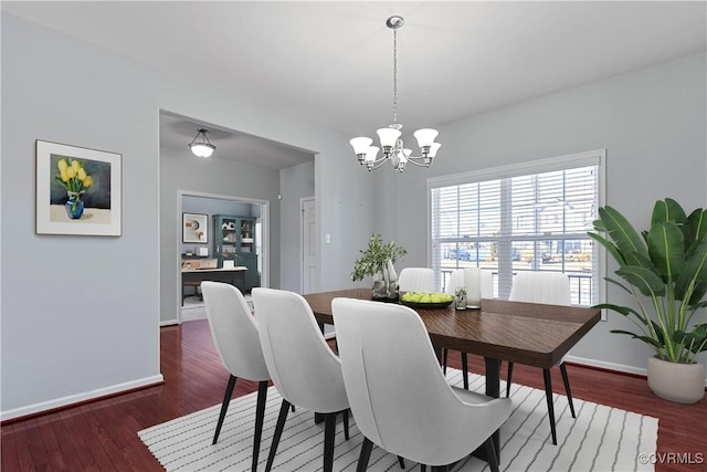 dining room featuring baseboards, an inviting chandelier, and wood finished floors