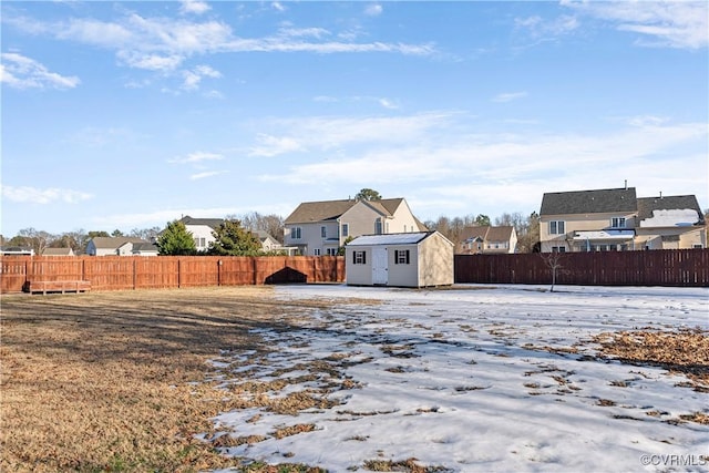 view of yard featuring a storage unit, an outdoor structure, a fenced backyard, and a residential view