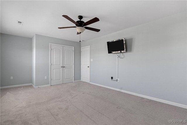 unfurnished bedroom with carpet floors, a closet, and baseboards