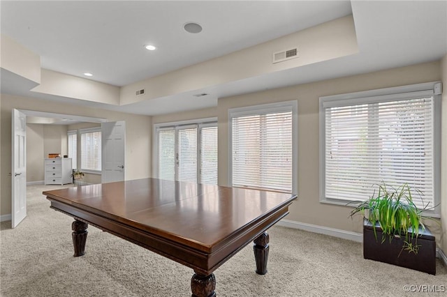 interior space featuring visible vents, baseboards, a wealth of natural light, and light colored carpet