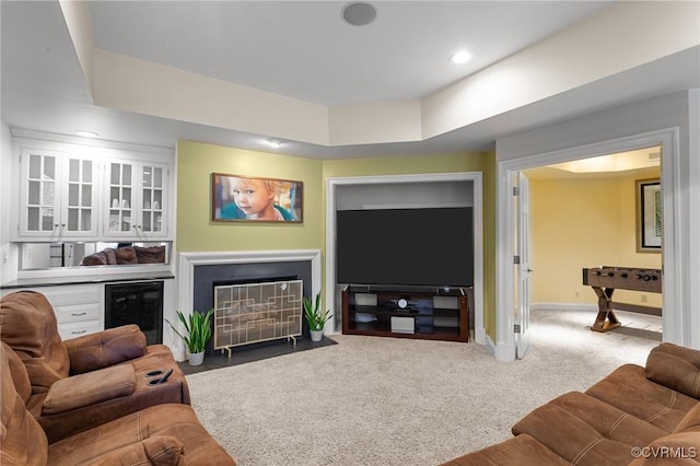 living area featuring carpet floors, recessed lighting, a fireplace with flush hearth, beverage cooler, and baseboards