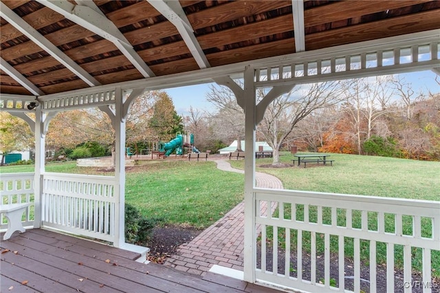 wooden deck featuring a lawn and a playground