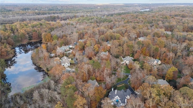 birds eye view of property featuring a forest view and a water view