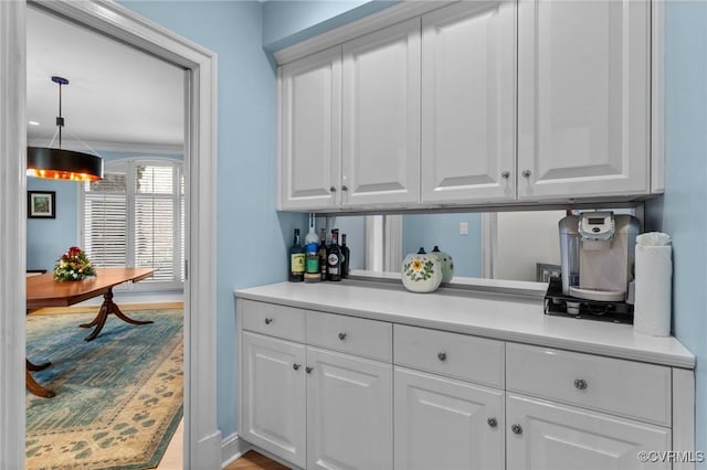 kitchen with white cabinetry, light countertops, and pendant lighting