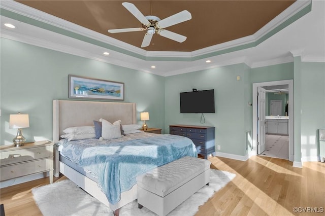 bedroom featuring recessed lighting, a raised ceiling, and wood finished floors