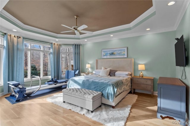 bedroom featuring a raised ceiling, a ceiling fan, wood finished floors, crown molding, and recessed lighting