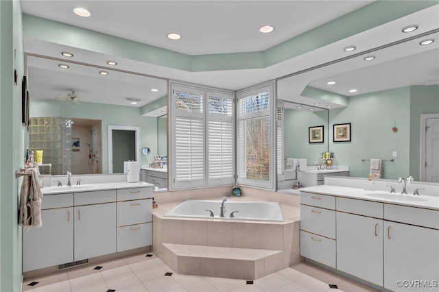 bathroom with visible vents, a sink, a shower stall, and a bath