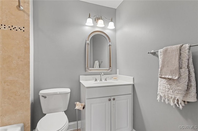 bathroom featuring toilet, walk in shower, vanity, and baseboards