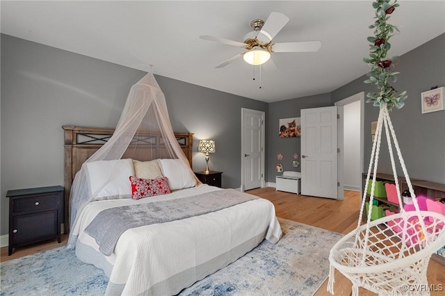 bedroom featuring wood finished floors, a ceiling fan, and baseboards