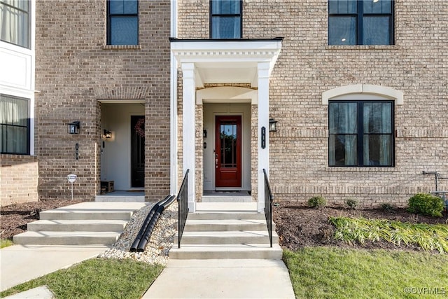 view of exterior entry with brick siding