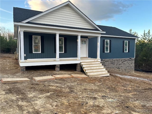 view of front of property featuring a porch and roof with shingles