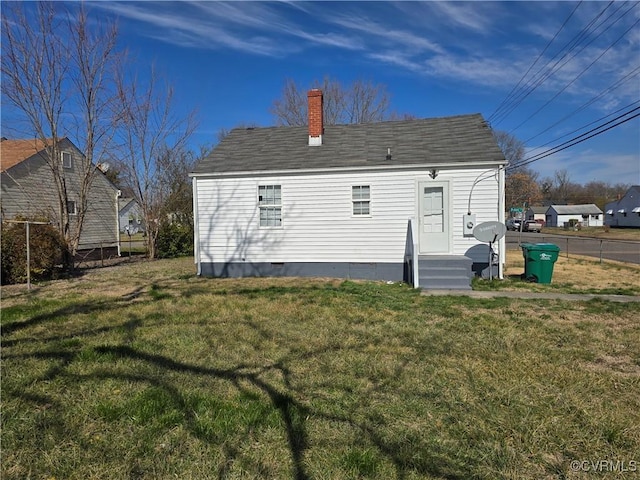 back of property featuring crawl space, a lawn, a chimney, and fence