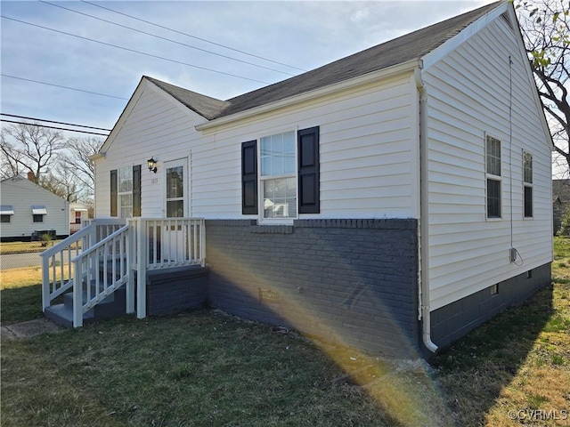 view of side of home featuring crawl space, a yard, and brick siding