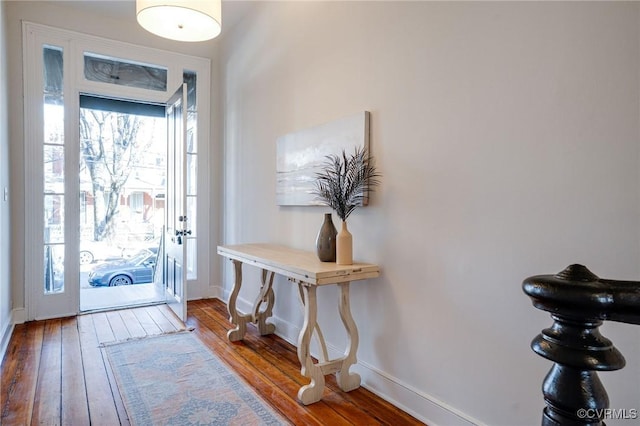 entryway with baseboards and hardwood / wood-style floors