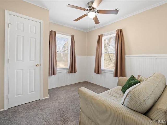 living area with carpet, plenty of natural light, and wainscoting