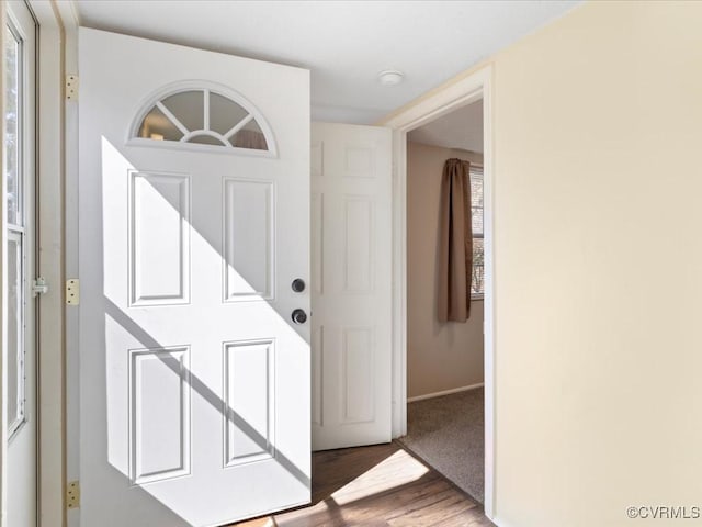 foyer with baseboards and wood finished floors