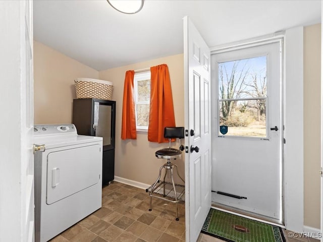 clothes washing area with washer / dryer, laundry area, and baseboards