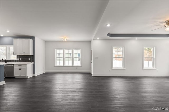 unfurnished living room featuring ceiling fan, recessed lighting, dark wood finished floors, and baseboards