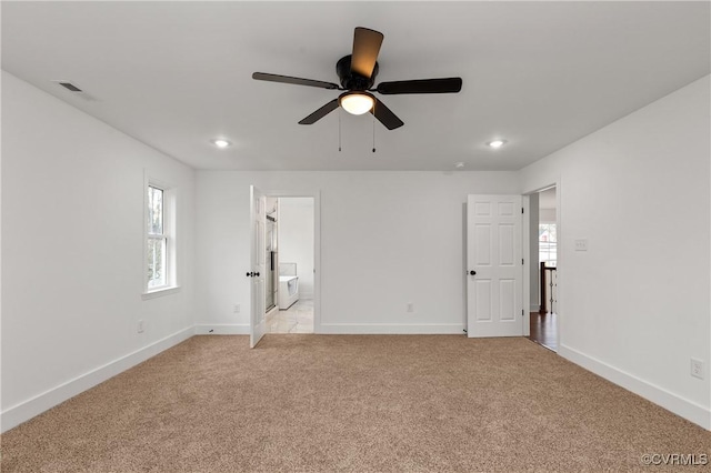 unfurnished bedroom with light carpet, recessed lighting, ensuite bathroom, and baseboards