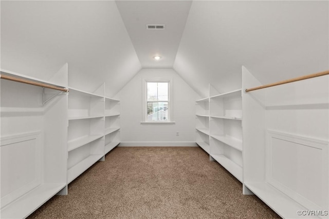 walk in closet featuring vaulted ceiling, carpet floors, and visible vents