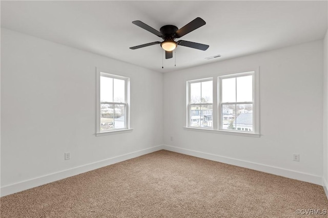 unfurnished room featuring a ceiling fan, carpet flooring, visible vents, and baseboards