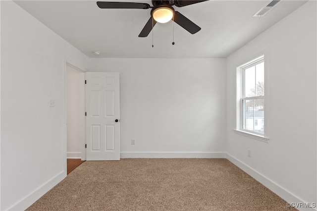 empty room with light carpet, visible vents, and baseboards