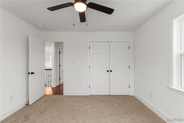 unfurnished bedroom featuring a closet, carpet flooring, ceiling fan, and baseboards