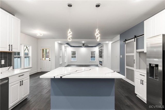 kitchen featuring white cabinets, dark wood-style floors, a barn door, and stainless steel appliances