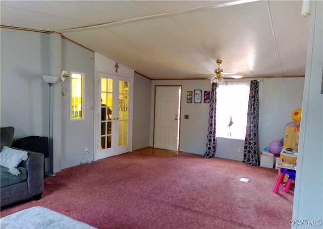 interior space featuring a ceiling fan, carpet, french doors, and lofted ceiling