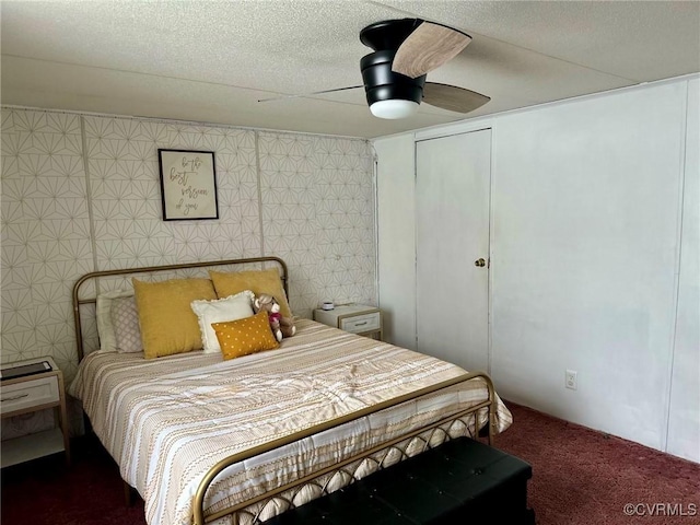 carpeted bedroom with a textured ceiling and a ceiling fan