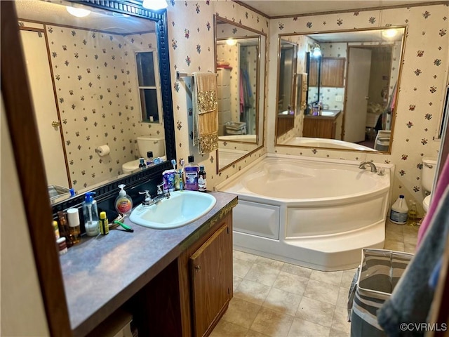 full bathroom featuring toilet, wallpapered walls, a garden tub, and vanity