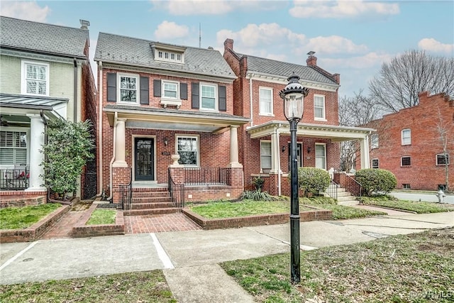 townhome / multi-family property with brick siding and a porch