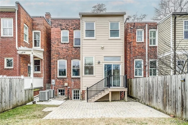 rear view of house with a patio, central AC unit, and fence