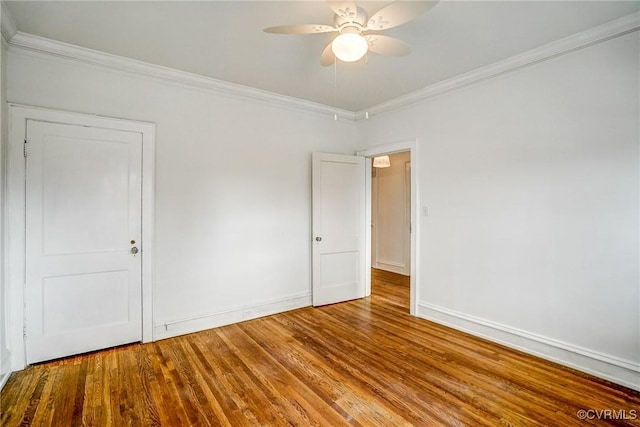 unfurnished room with baseboards, a ceiling fan, wood finished floors, and crown molding