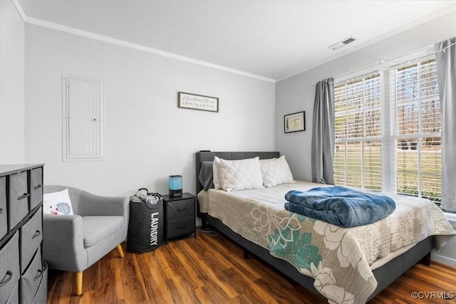 bedroom with ornamental molding, visible vents, and dark wood finished floors