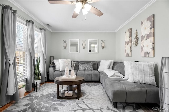 living area featuring a ceiling fan, ornamental molding, and wood finished floors