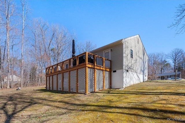 view of side of home with a yard and a wooden deck