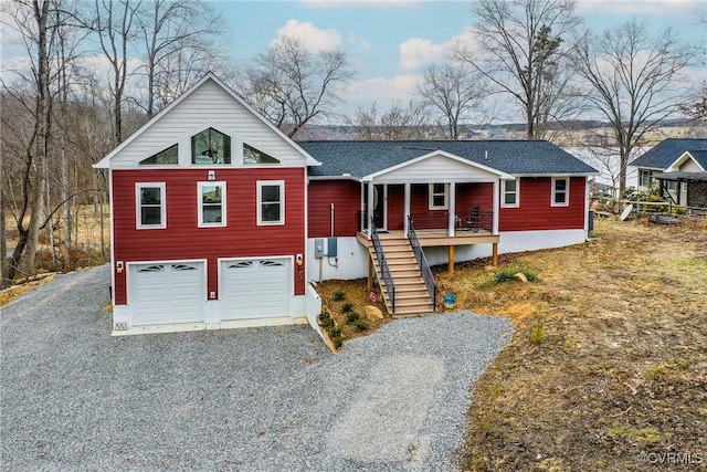 view of front facade featuring a garage, stairway, roof with shingles, gravel driveway, and covered porch