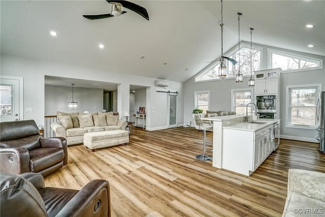 kitchen featuring open floor plan, light countertops, a breakfast bar area, and a barn door