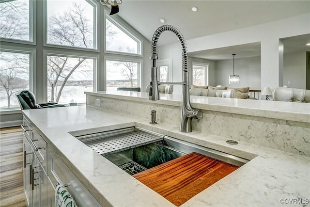 room details with light stone counters, a sink, and a jacuzzi