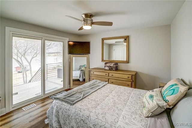 bedroom with access to exterior, a ceiling fan, visible vents, and wood finished floors