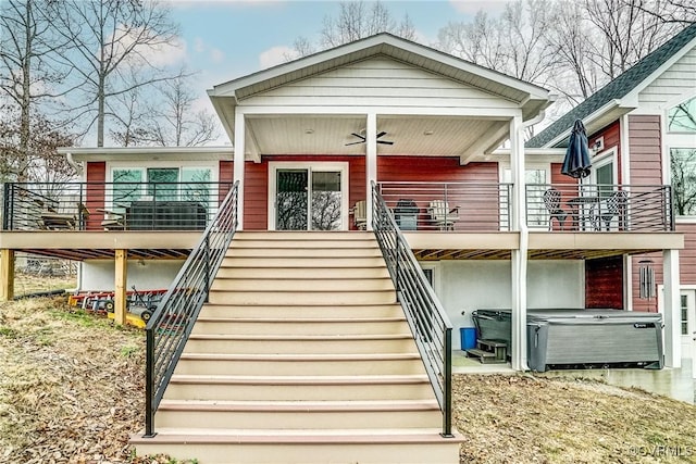 view of front of home with stairs, a ceiling fan, and a hot tub