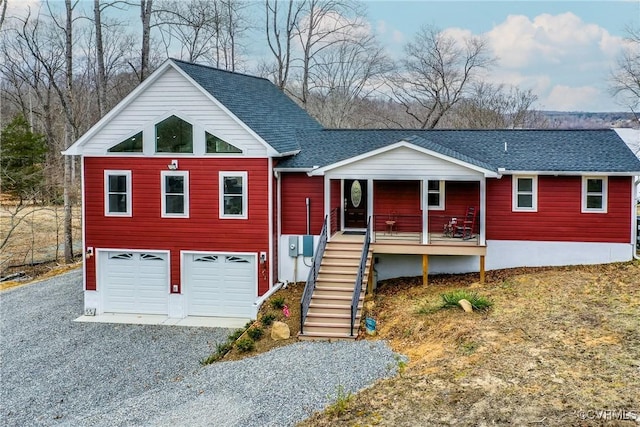 view of front of property with covered porch, driveway, stairway, and an attached garage