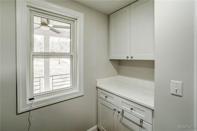 interior space featuring ceiling fan and baseboards