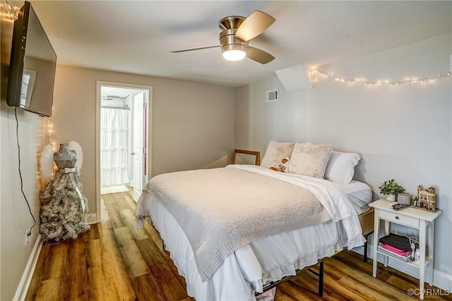 bedroom with a ceiling fan, baseboards, visible vents, and wood finished floors