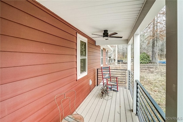 wooden deck featuring covered porch and ceiling fan